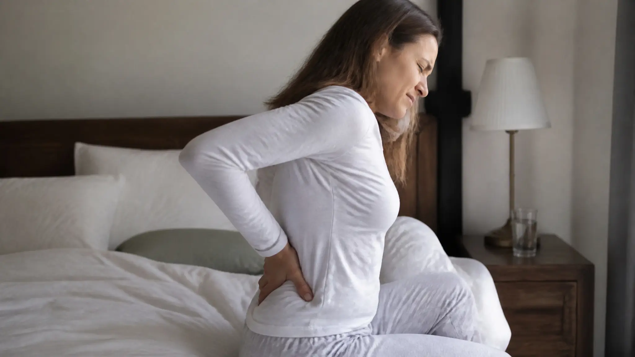 A young lady with back pain in bed